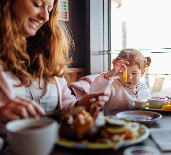 Mum and daughter tucking into a takeaway at home to promote Howard Insurance Brokers - Retail and Takeaways Insurance